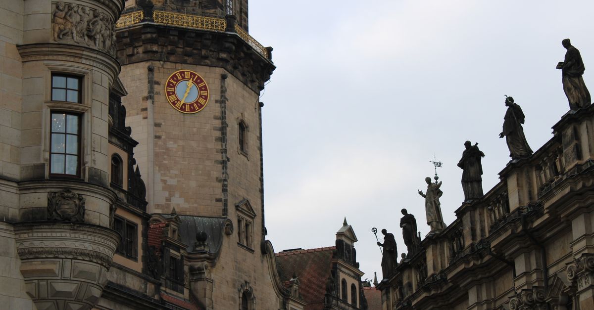 Detailreiche Fassade des Dresdner Schlosses, daneben Dachfiguren der Kathedrale auf der Dachkante