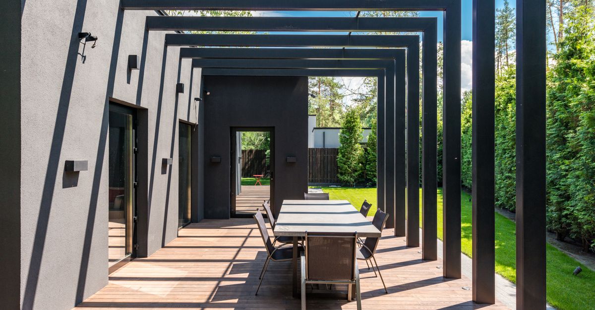 Eine m&ouml;blierte Terrasse mit verstellbarem Lamellendach und gedecktem Esstisch